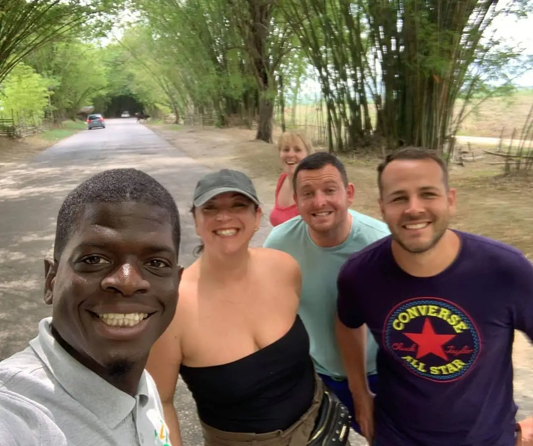 An Inside Tours Jamaica guide with a smiling group of guests on a countryside tour