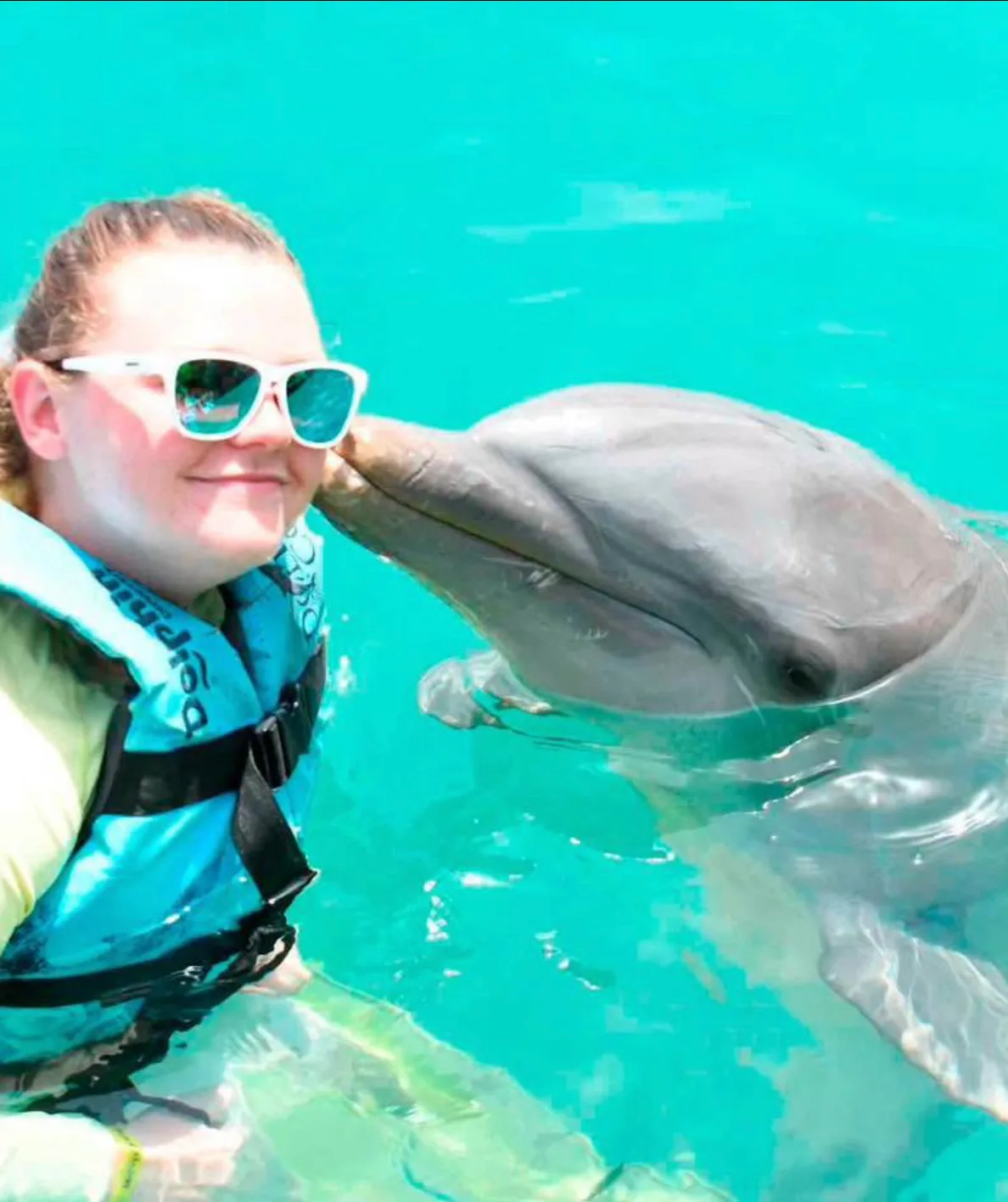 A guest swimming with a dolphin on an Inside Tours Jamaica excursion