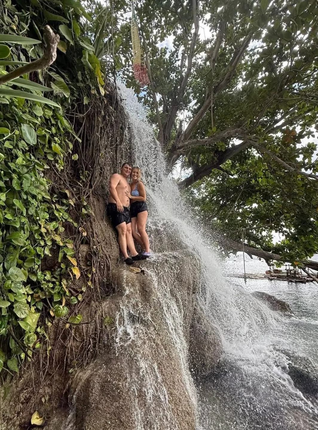 Guests posing together at a waterfall on a Jamaica tour